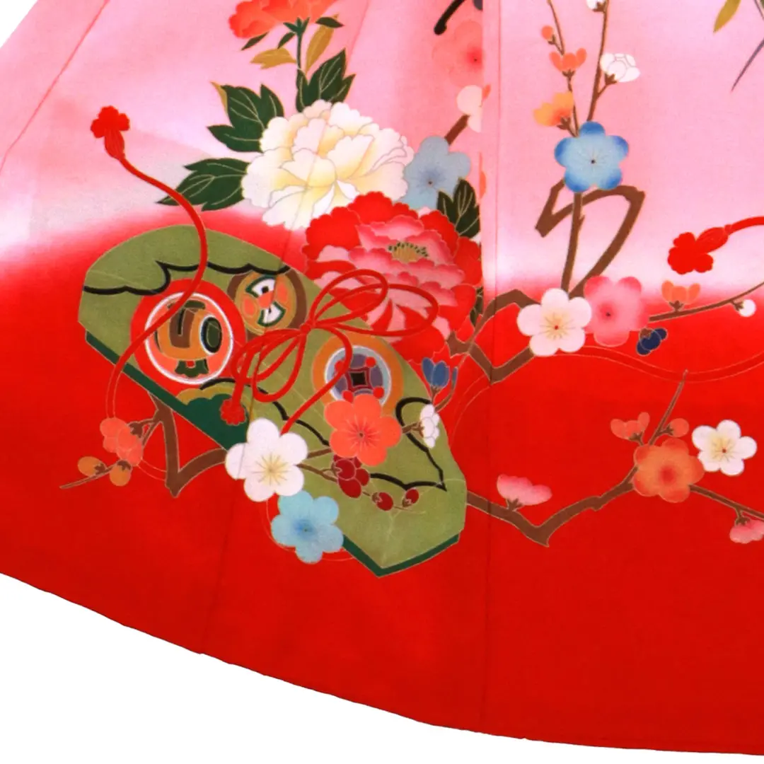 お宮参り産着／薄橙色とピンクと赤の熨斗目に花車の祝い着／女児／左裾詳細