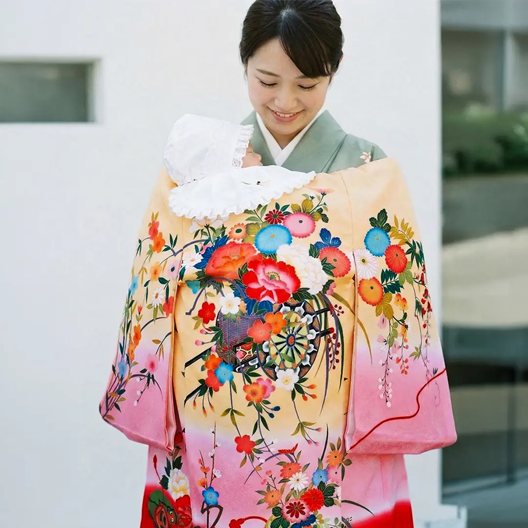 お宮参り産着／薄橙色とピンクと赤の熨斗目に花車の祝い着／女児／着用イメージ